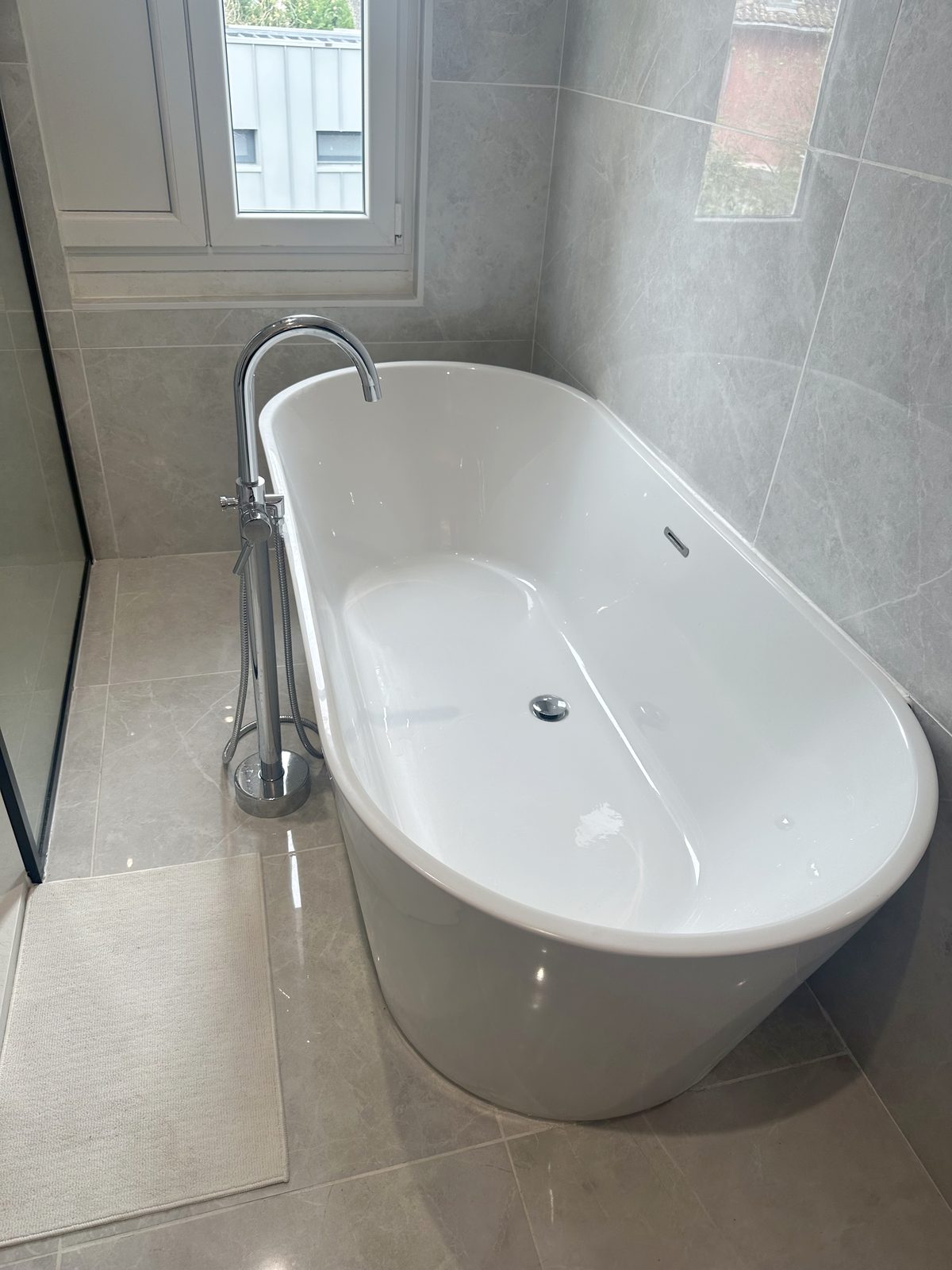 Baignoire îlot ovale design dans une salle de bain rénovée — NS BAT 33 Bordeaux