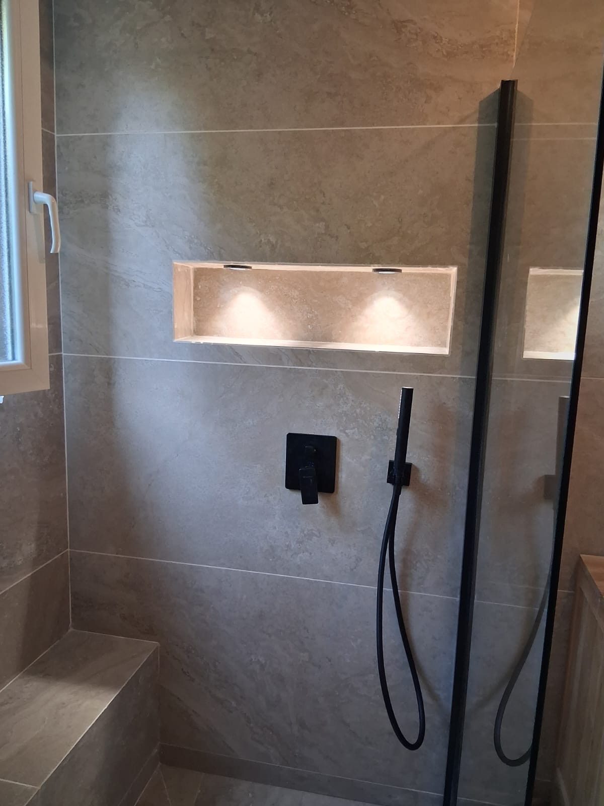 Niche travertin éclairée et robinetterie noire — NS BAT 33 Bordeaux