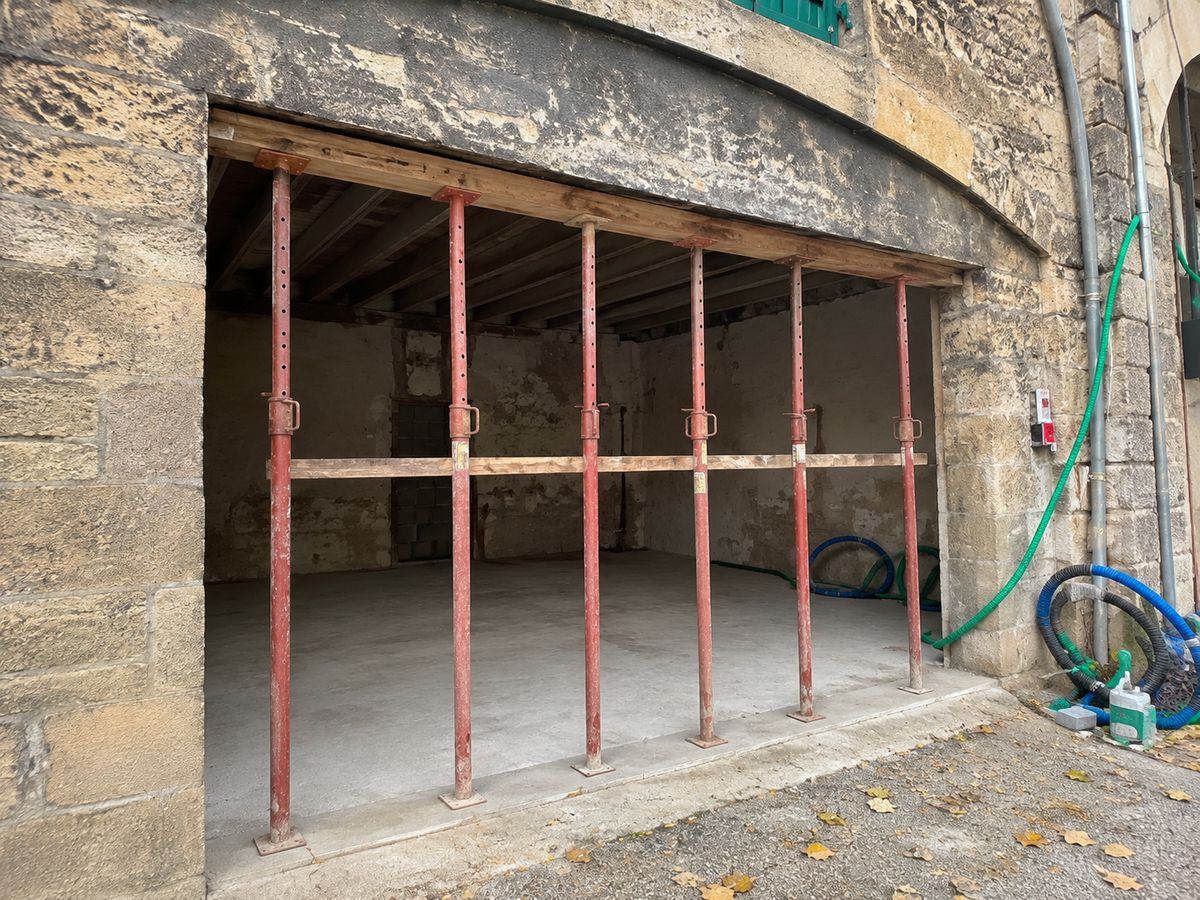Ouverture de baie en façade pierre à Bordeaux par NS BAT 33 : étais métalliques et chevêtre bois en attente du linteau